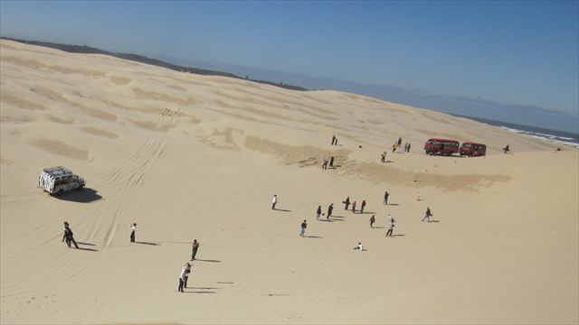 ストックトン砂丘の斜面とサンドボードを楽しむ人々